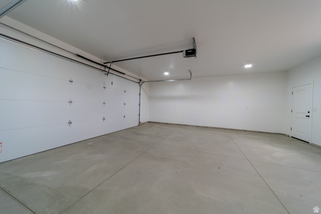 130 Pole Line Road, Unit 2 Roosevelt, UT 84066 - Photo 29 of 33 Spacious garage with light grey concrete flooring, white walls, and bright recessed lighting