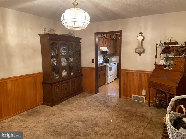 a view of a livingroom with furniture and kitchen view