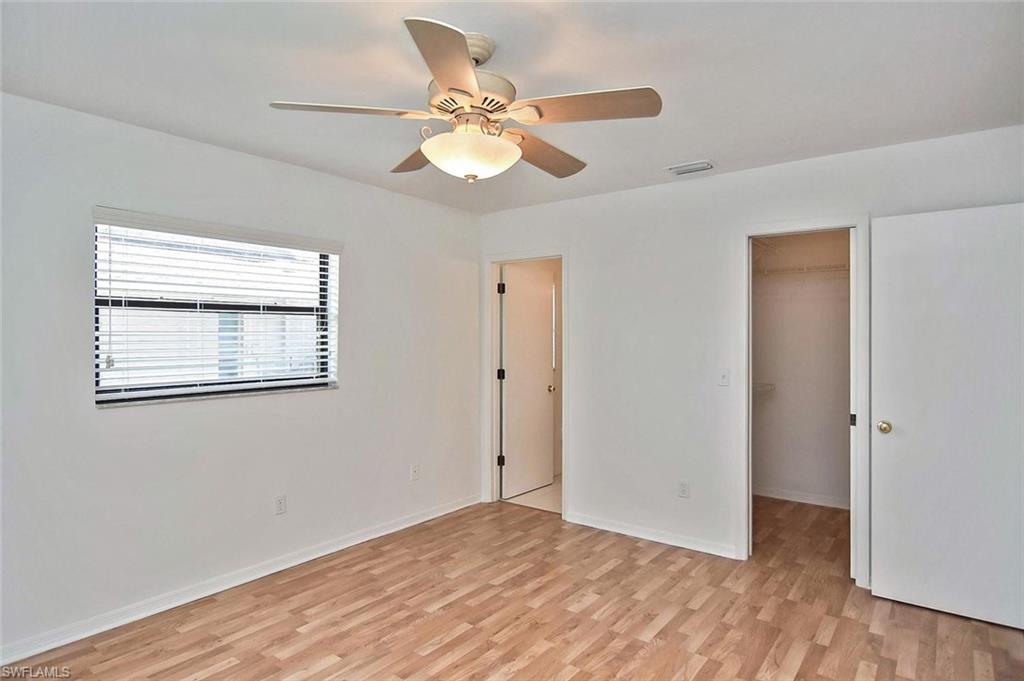 17533 Oriole Road Fort Myers, FL 33967 - Photo 17 of 35 a view of an empty room with wooden floor and a ceiling fan