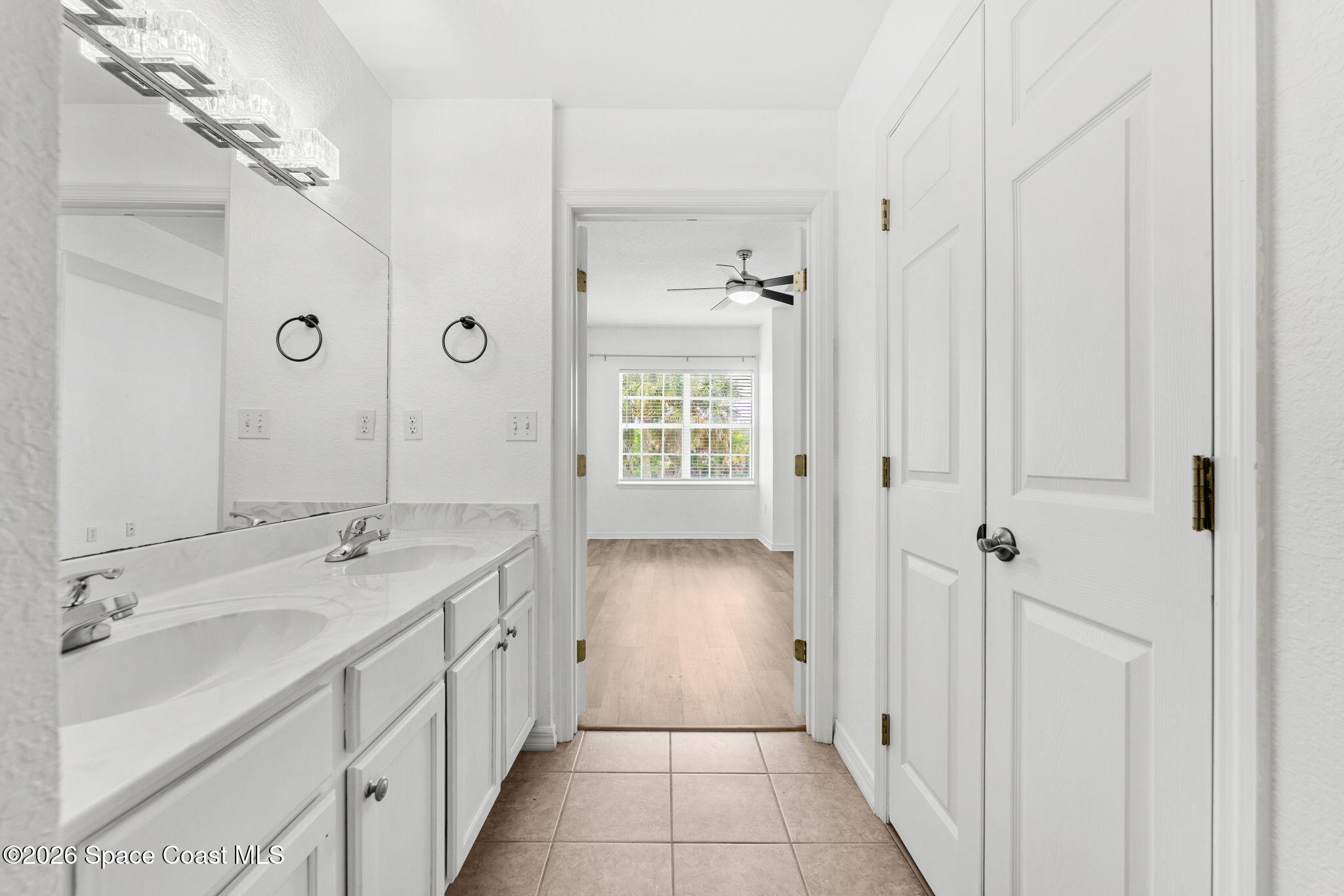 110 Turpial Way, Unit 106 Melbourne, FL 32901 - Photo 23 of 50 a bathroom with a double vanity sink and mirror