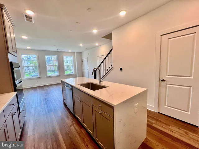a kitchen with a sink and wooden floor