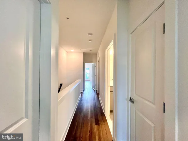 a view of a hallway with wooden floor and staircase