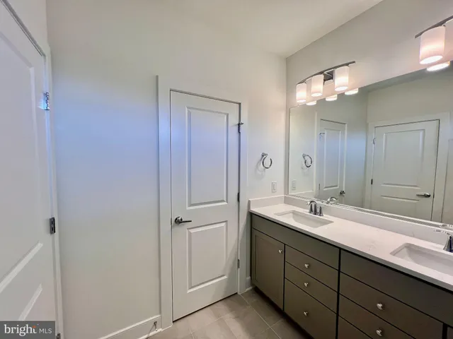 a bathroom with a double vanity sink and mirror with shower