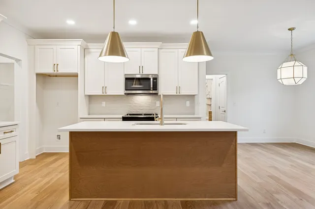 a kitchen with stainless steel appliances granite countertop a sink a stove and a refrigerator