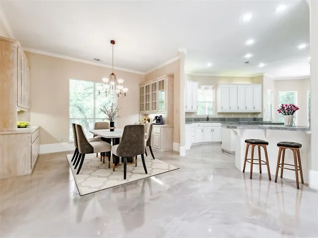 a kitchen with kitchen island granite countertop white cabinets and white stainless steel appliances
