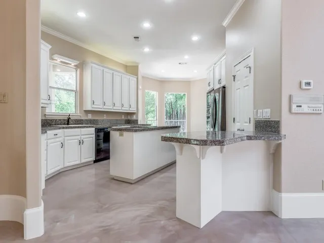 a kitchen with white cabinets and stainless steel appliances