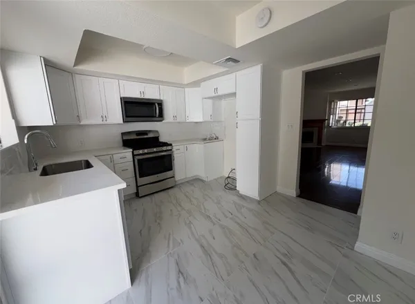 a kitchen with a refrigerator and a stove top oven