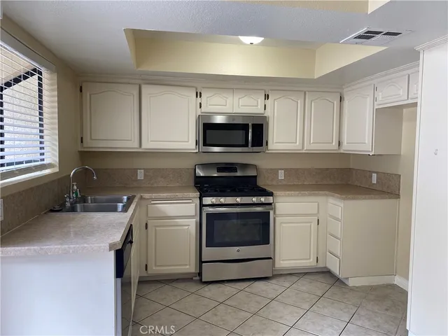 a kitchen with granite countertop white cabinets and appliances