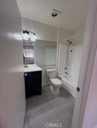 a bathroom with a toilet sink a mirror and shower