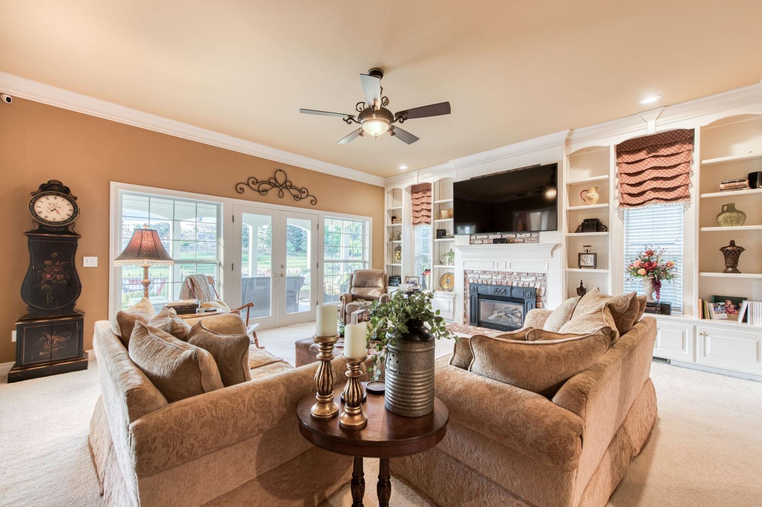 21672 Westmere Lane Friant, CA 93626 - Photo 19 of 80 a living room with furniture a fireplace and a flat screen tv