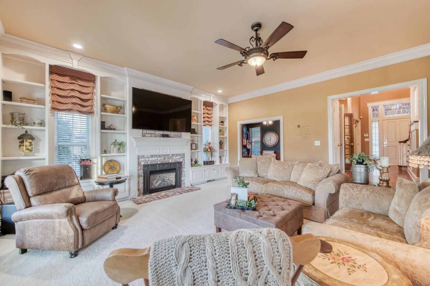 21672 Westmere Lane Friant, CA 93626 - Photo 22 of 80 a living room with furniture a fireplace and a flat screen tv