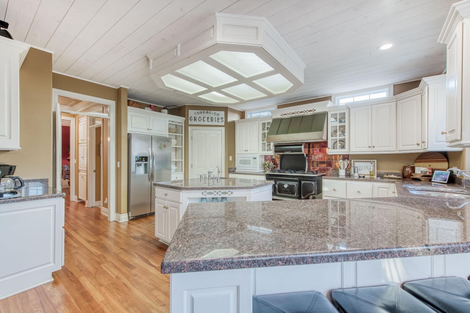 21672 Westmere Lane Friant, CA 93626 - Photo 26 of 80 a kitchen with stainless steel appliances granite countertop a stove refrigerator and cabinets