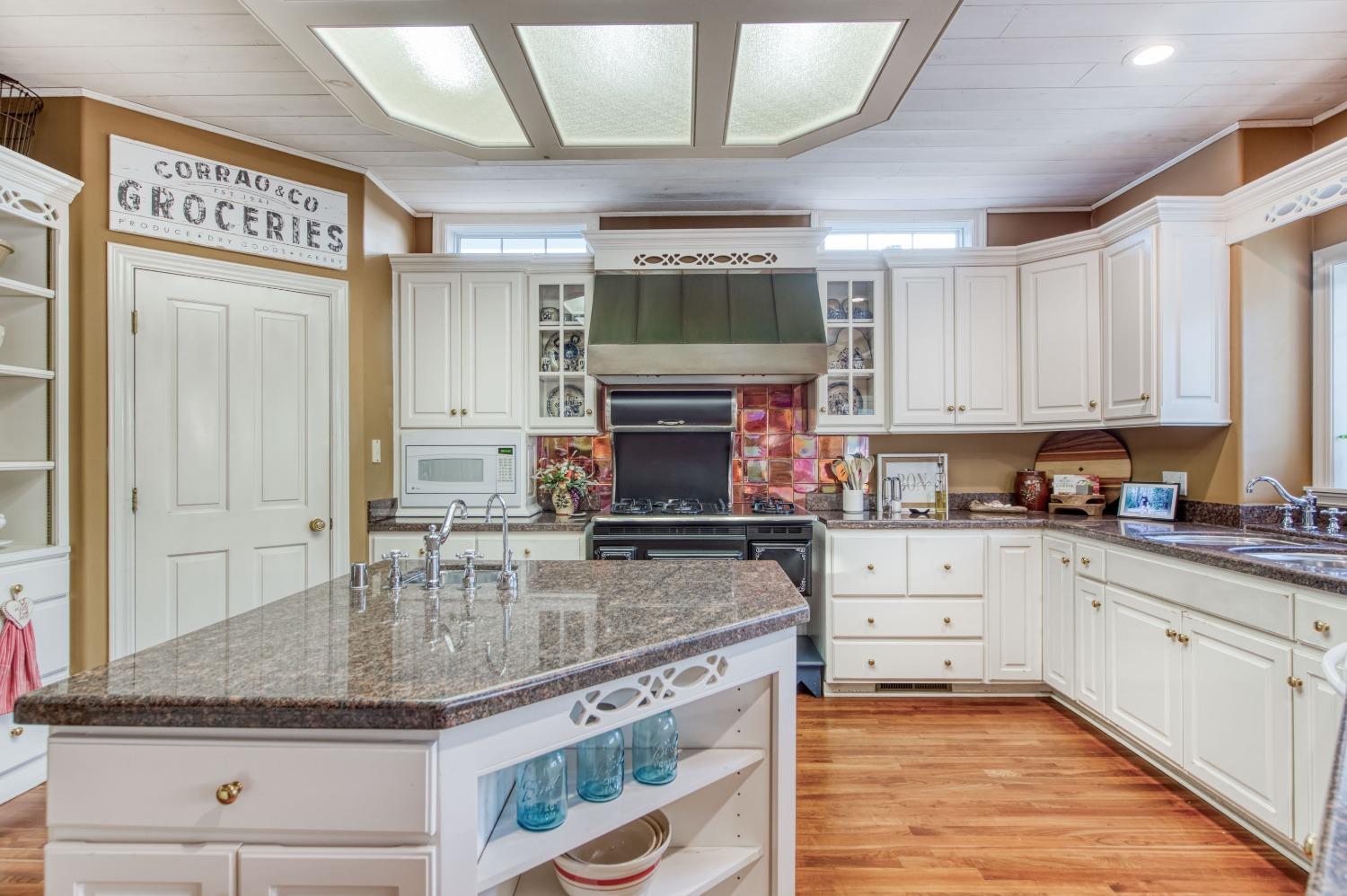 21672 Westmere Lane Friant, CA 93626 - Photo 27 of 80 a kitchen with stainless steel appliances granite countertop a stove sink and cabinets