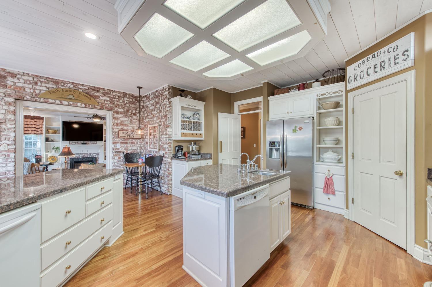 21672 Westmere Lane Friant, CA 93626 - Photo 28 of 80 a open kitchen with stainless steel appliances granite countertop a lot of counter space and wooden floors