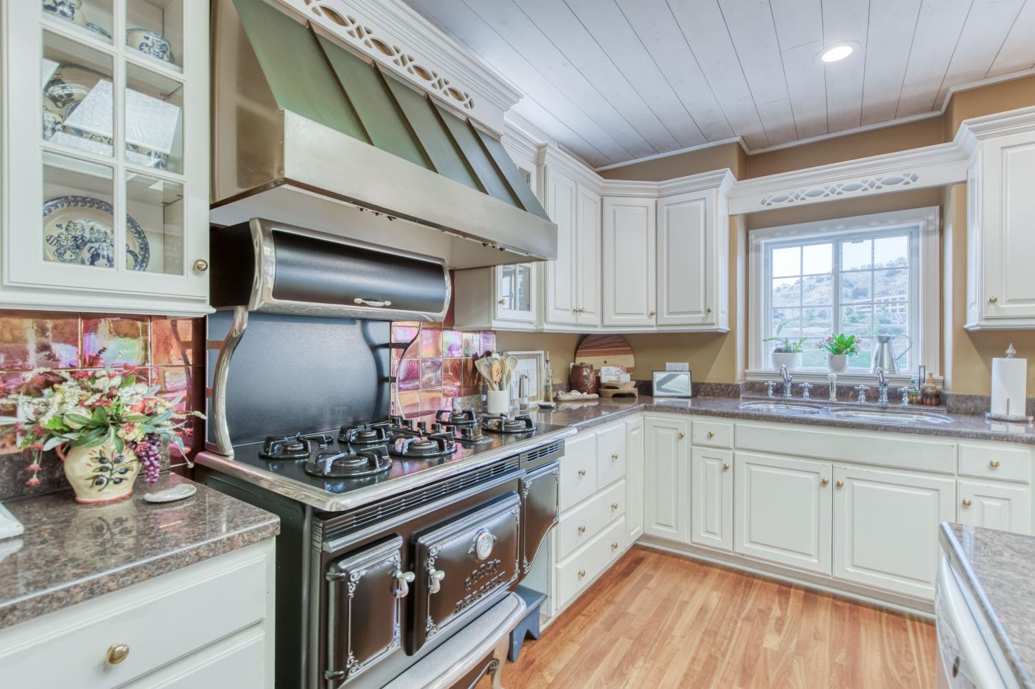 21672 Westmere Lane Friant, CA 93626 - Photo 30 of 80 a kitchen with stainless steel appliances kitchen island granite countertop a stove a sink and cabinets