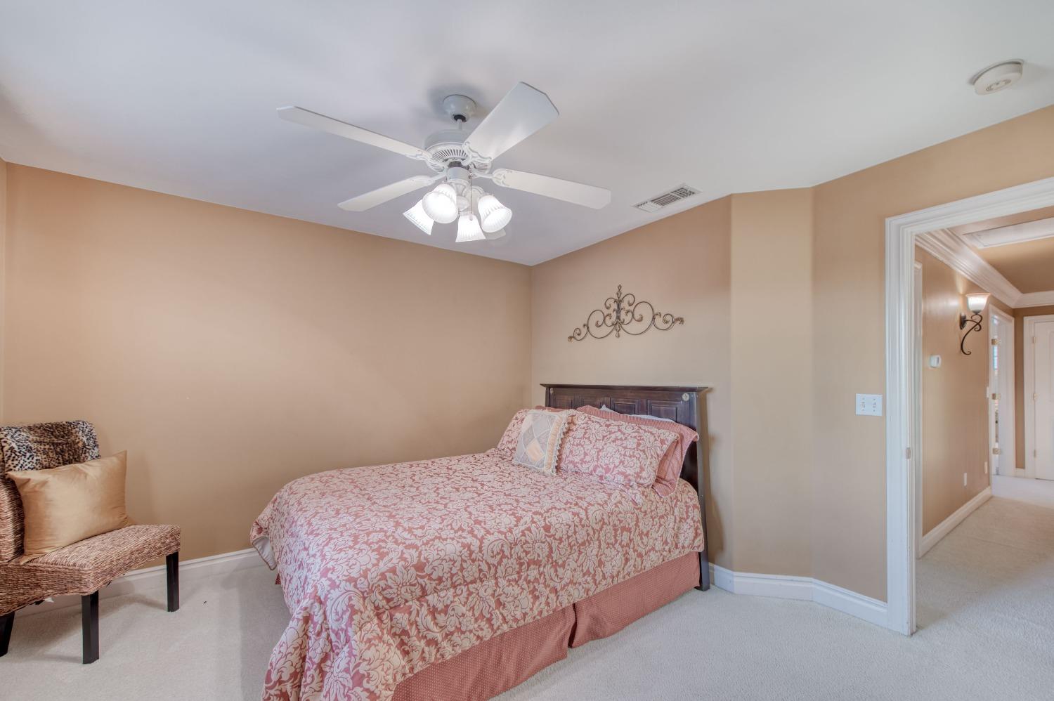 21672 Westmere Lane Friant, CA 93626 - Photo 40 of 80 a bedroom with a bed and a chandelier