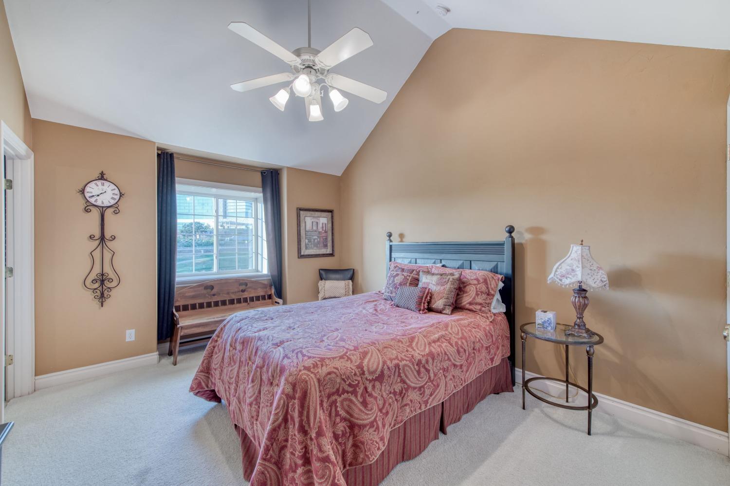 21672 Westmere Lane Friant, CA 93626 - Photo 41 of 80 a bedroom with a large bed and a chandelier