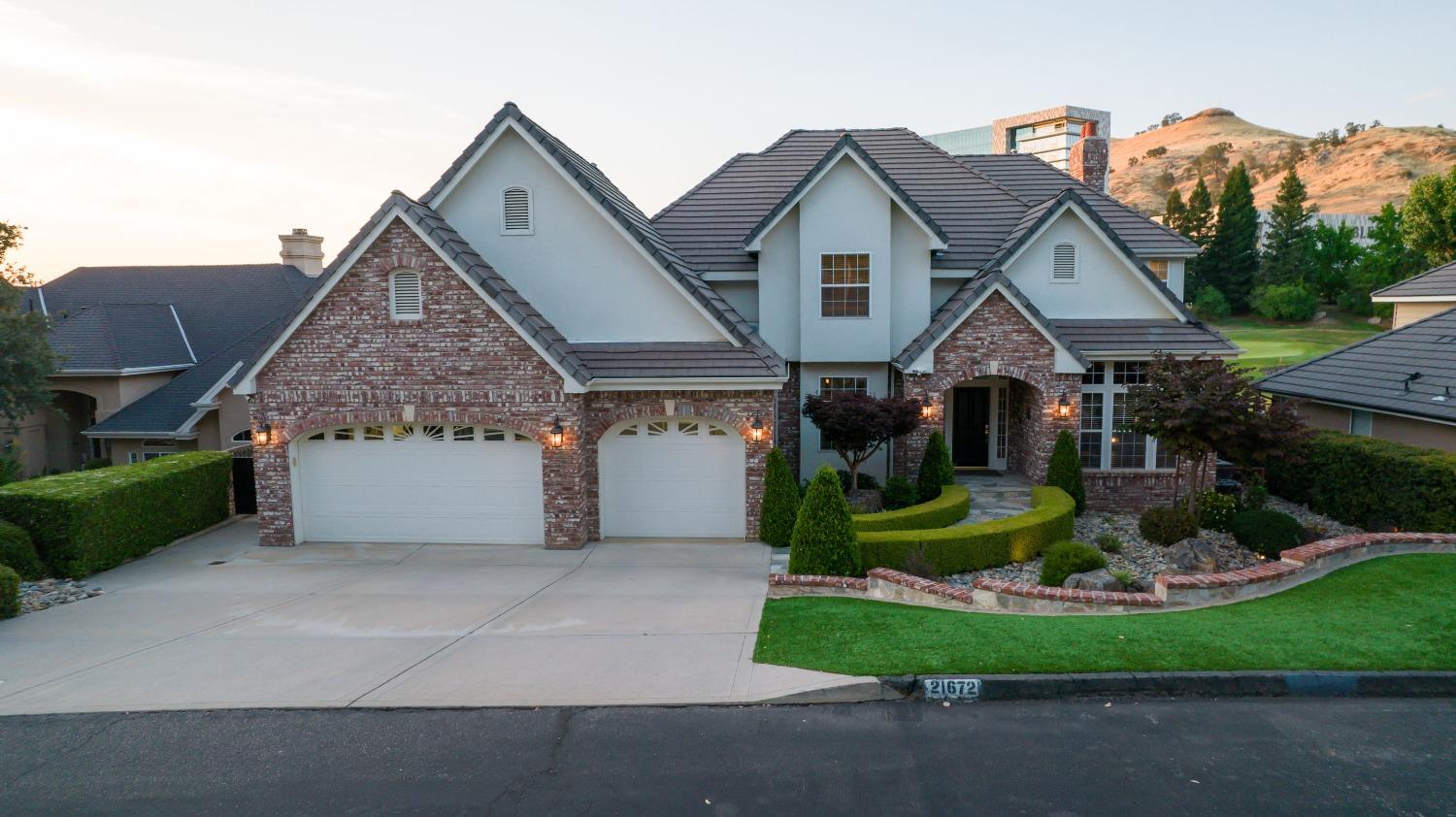 21672 Westmere Lane Friant, CA 93626 - Photo 69 of 80 a front view of a house with a garden and plants