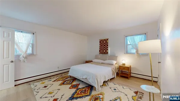 a bedroom with a bed and a lamp on the dresser