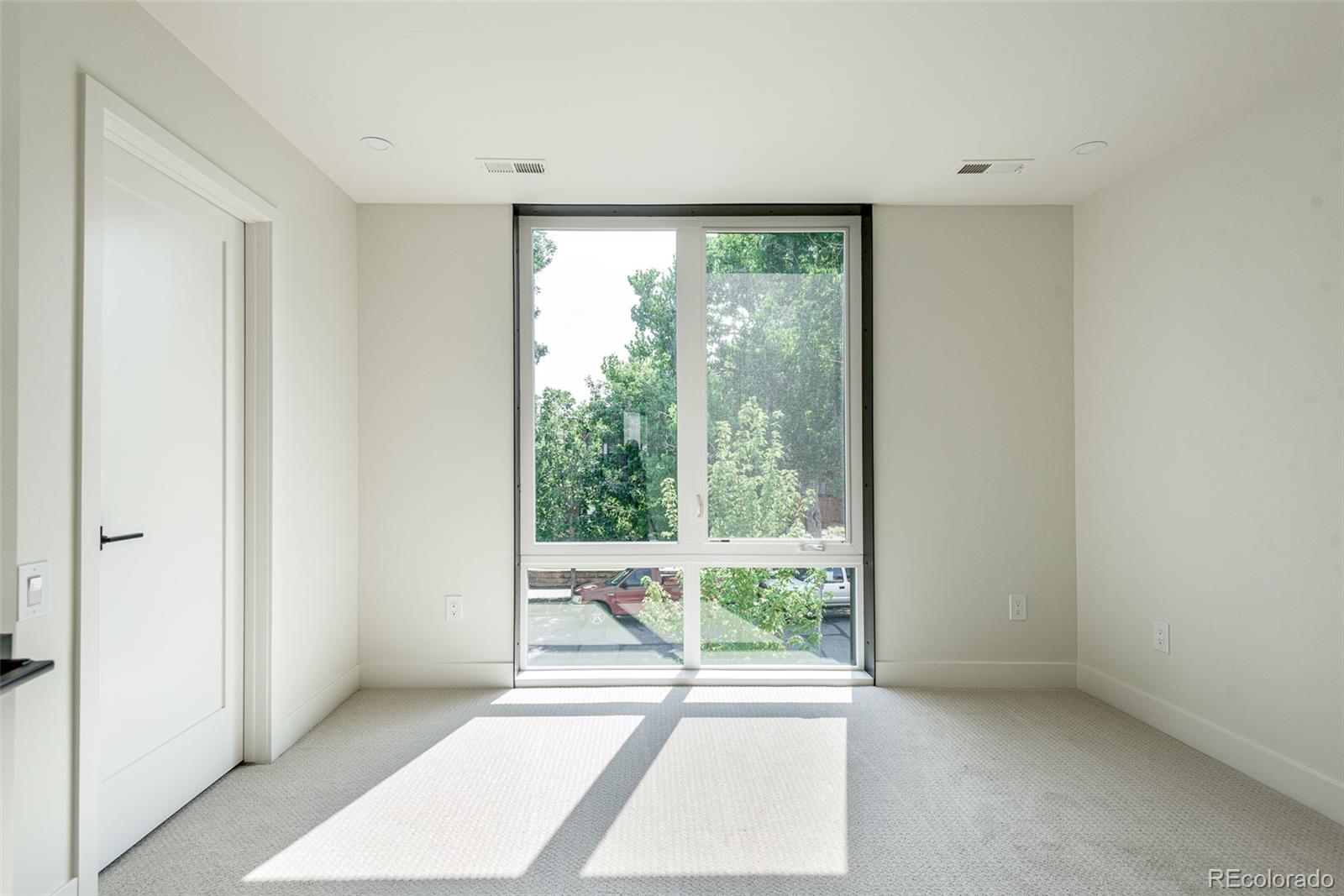 3865 Stuart Street Denver, CO 80212 - Photo 22 of 32 a view of an empty room with wooden floor and a window