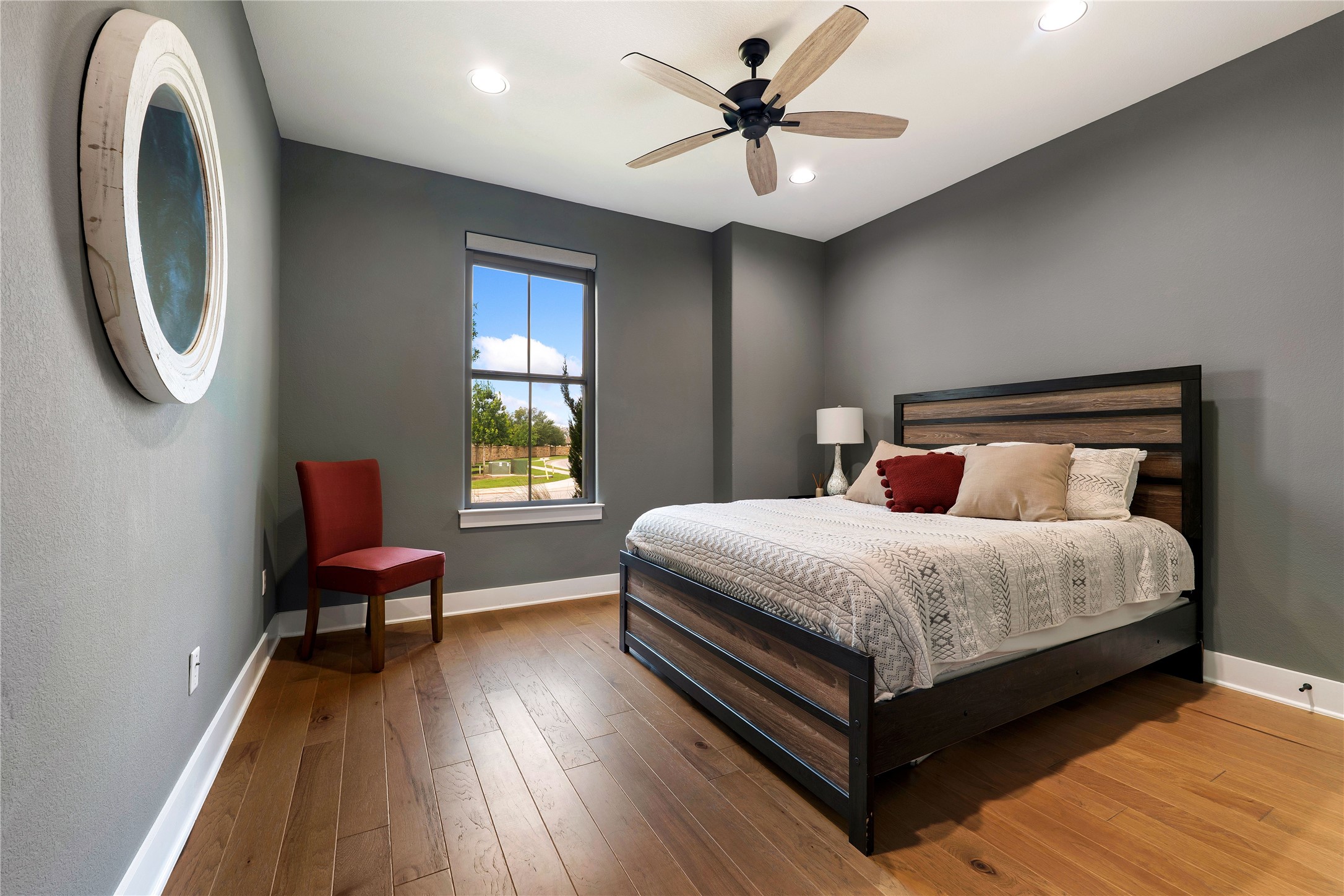 2408 Nate's Place Georgetown, TX 78633 - Photo 25 of 40 Elegant bedroom with durable hardwood floors and a ceiling fan, perfect for restful evenings.