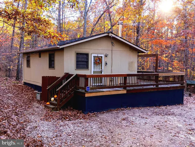 a backyard of a house with wooden fence and large trees