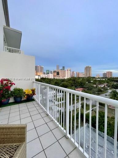 a view of a balcony with wooden floor and iron fence