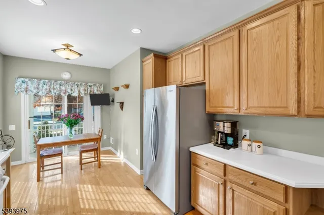 a kitchen with stainless steel appliances granite countertop a refrigerator and a wooden cabinets