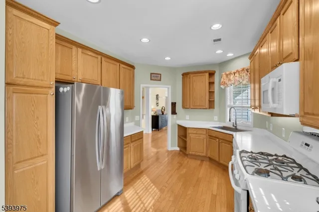 a kitchen with stainless steel appliances granite countertop a refrigerator stove and sink
