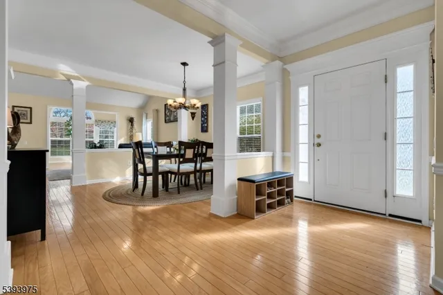 a dining room with wooden floor a chandelier a glass table and chairs