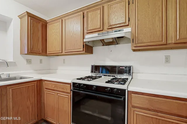 a kitchen with stainless steel appliances granite countertop a stove a sink and a refrigerator