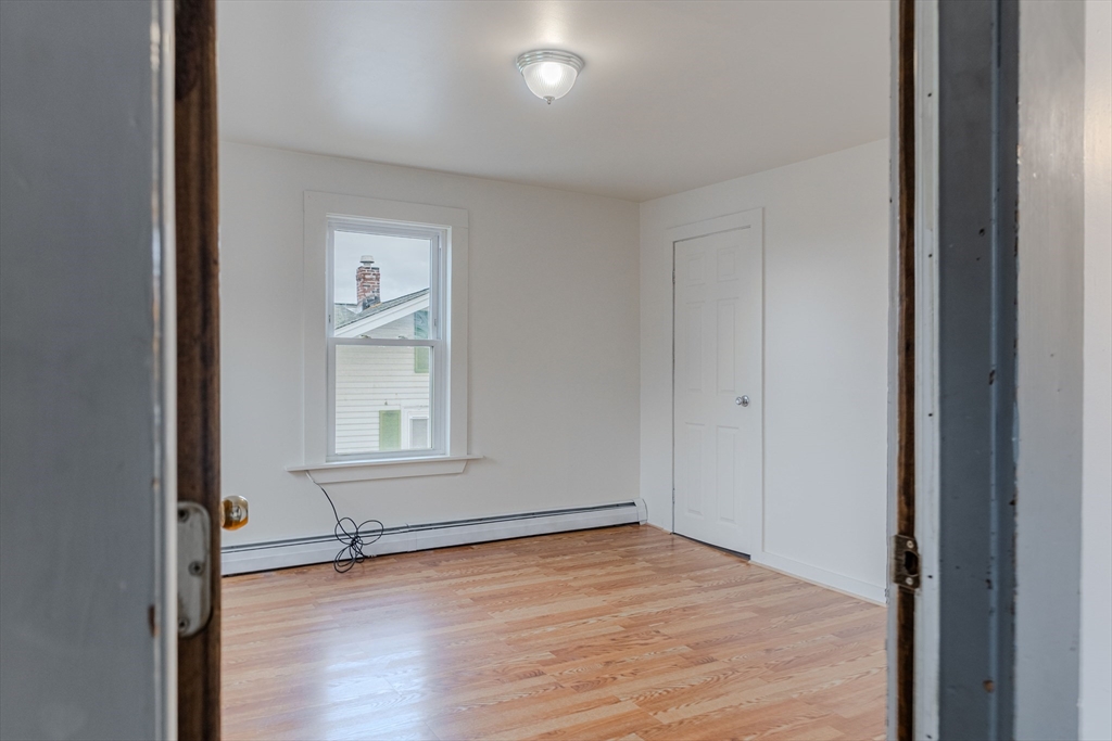 34 Perkins Street, Unit 2 Gloucester, MA 01930 - Photo 2 of 19 an empty room with wooden floor and windows