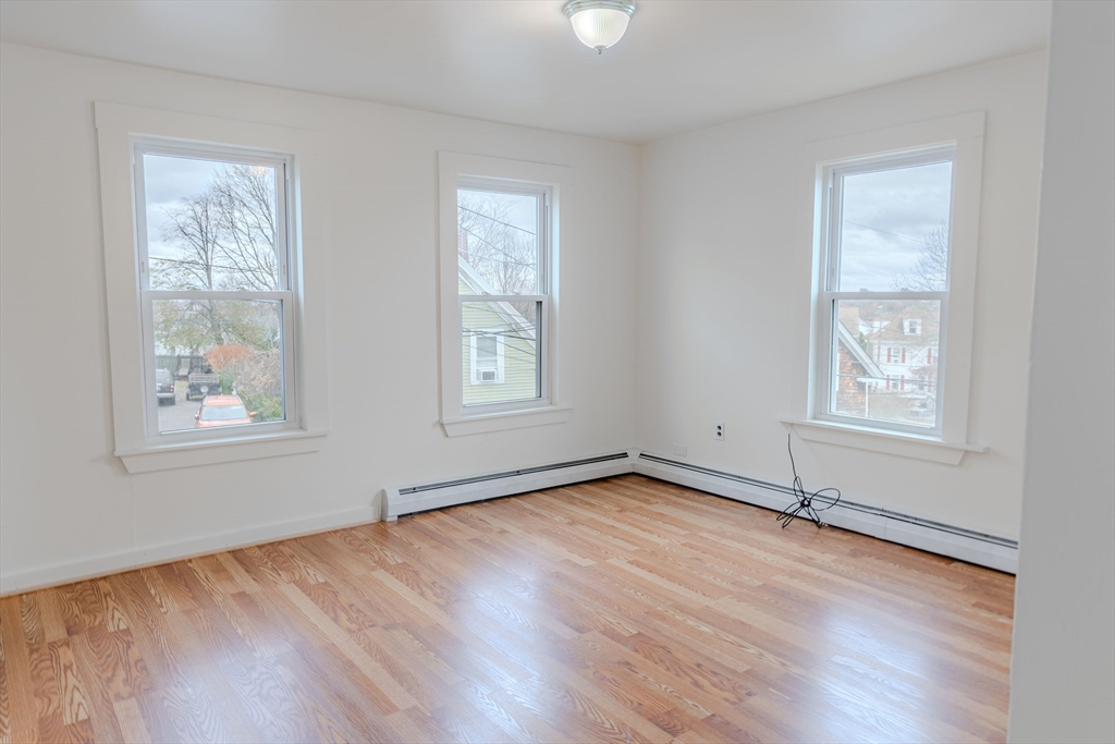 34 Perkins Street, Unit 2 Gloucester, MA 01930 - Photo 5 of 19 an empty room with wooden floor and windows