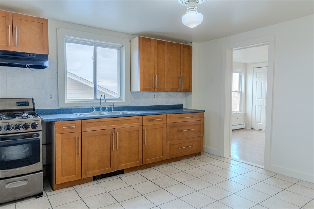 34 Perkins Street, Unit 2 Gloucester, MA 01930 - Photo 7 of 19 a kitchen with stainless steel appliances granite countertop a sink and a stove