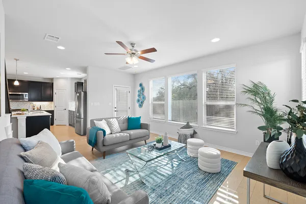 a living room with furniture a window and a potted plant