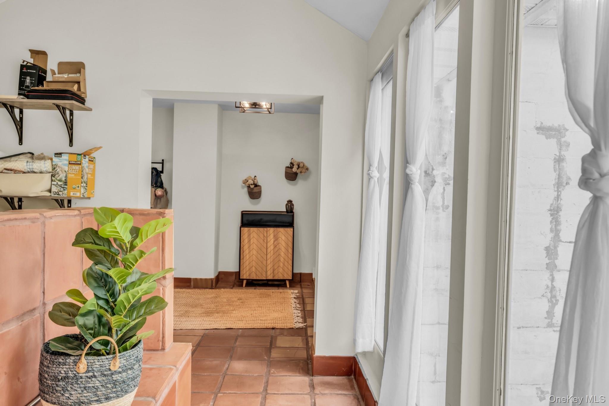 64 Sally Lane Ridge, NY 11961 - Photo 15 of 18 Hallway featuring vaulted ceiling and light tile patterned flooring