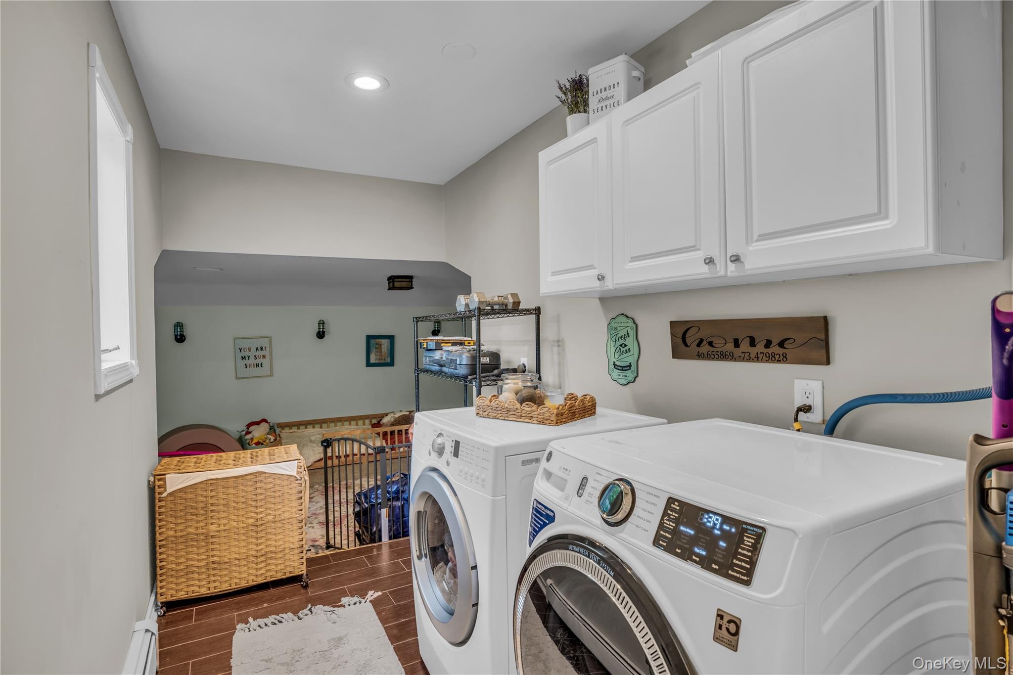 64 Sally Lane Ridge, NY 11961 - Photo 17 of 18 Laundry area with wood tiled floors, cabinet space, and washing machine and dryer