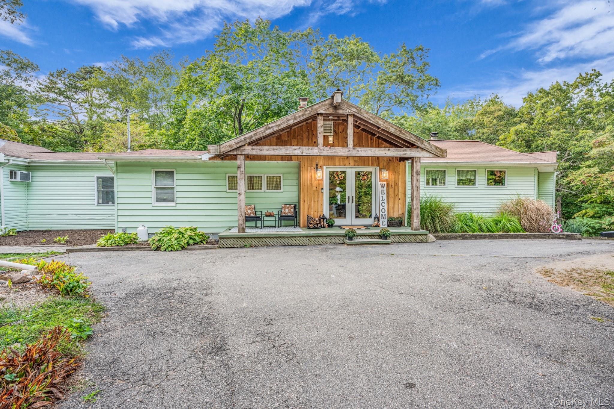 64 Sally Lane Ridge, NY 11961 - Photo 2 of 18 View of front of house with french doors, covered porch, and a chimney