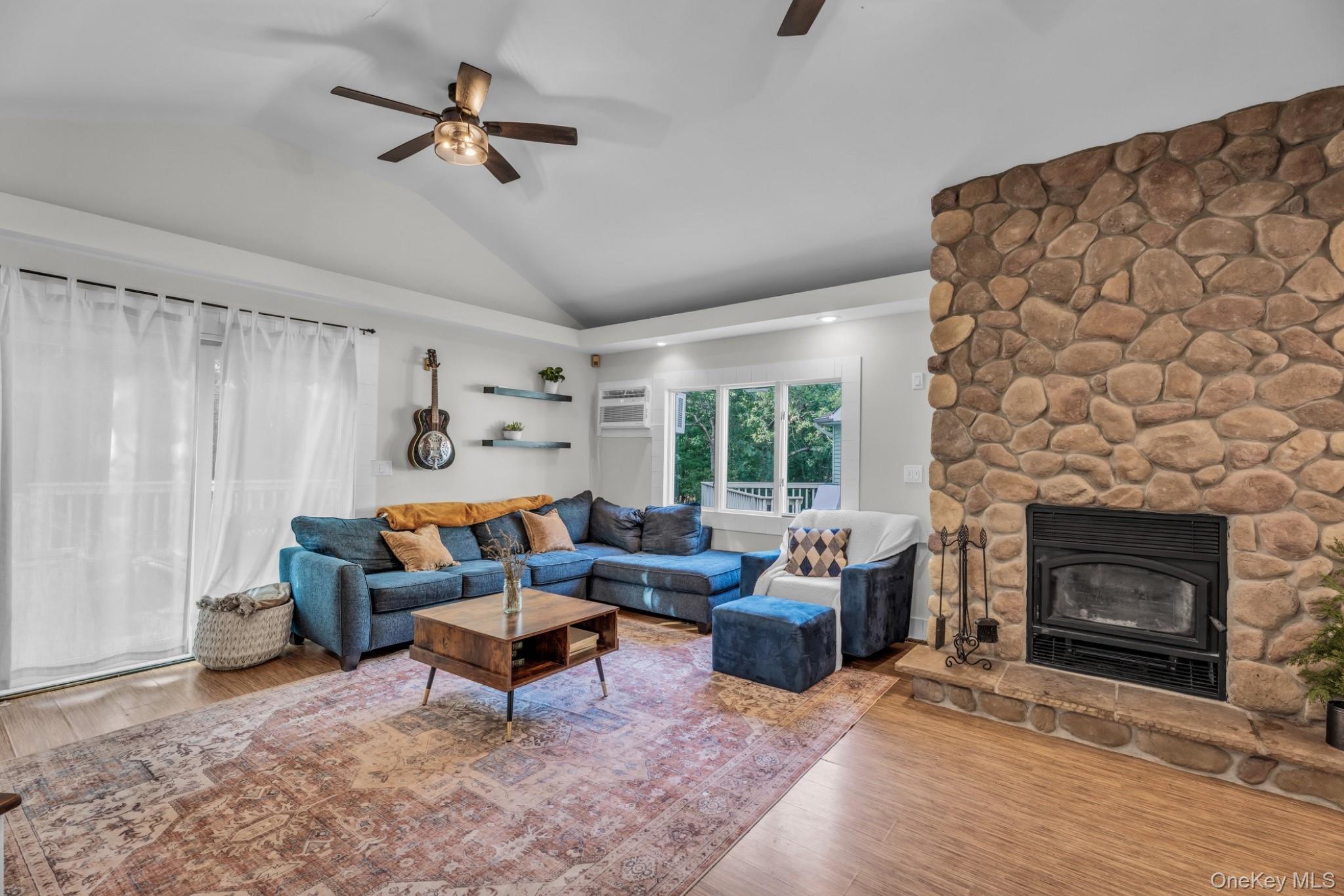 64 Sally Lane Ridge, NY 11961 - Photo 4 of 18 Living area featuring a ceiling fan, wood finished floors, a stone fireplace, and lofted ceiling