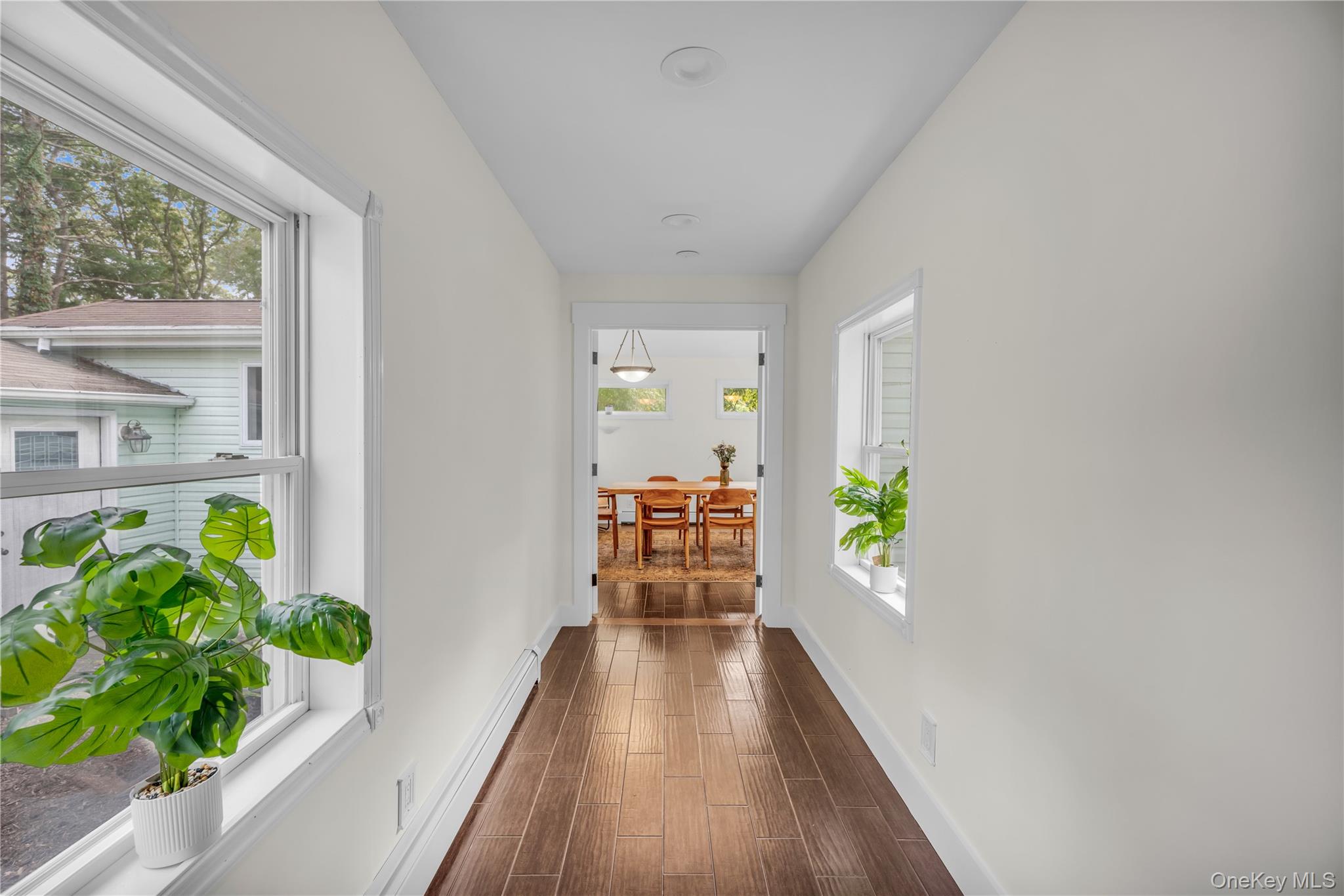64 Sally Lane Ridge, NY 11961 - Photo 8 of 18 Corridor featuring baseboard heating and wood finish floors