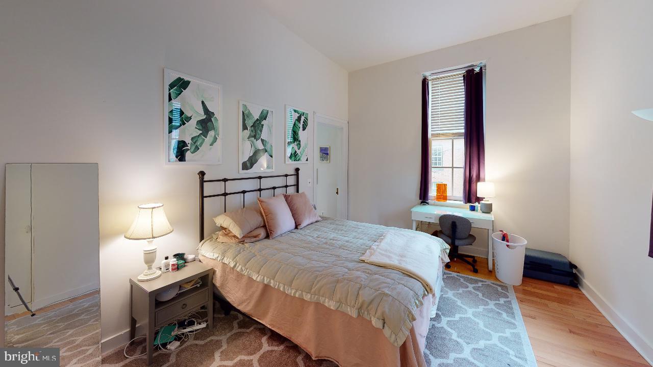 260 South 9th Street, Unit 2F Philadelphia, PA 19107 - Photo 7 of 8 a bedroom with a bed and wooden floor