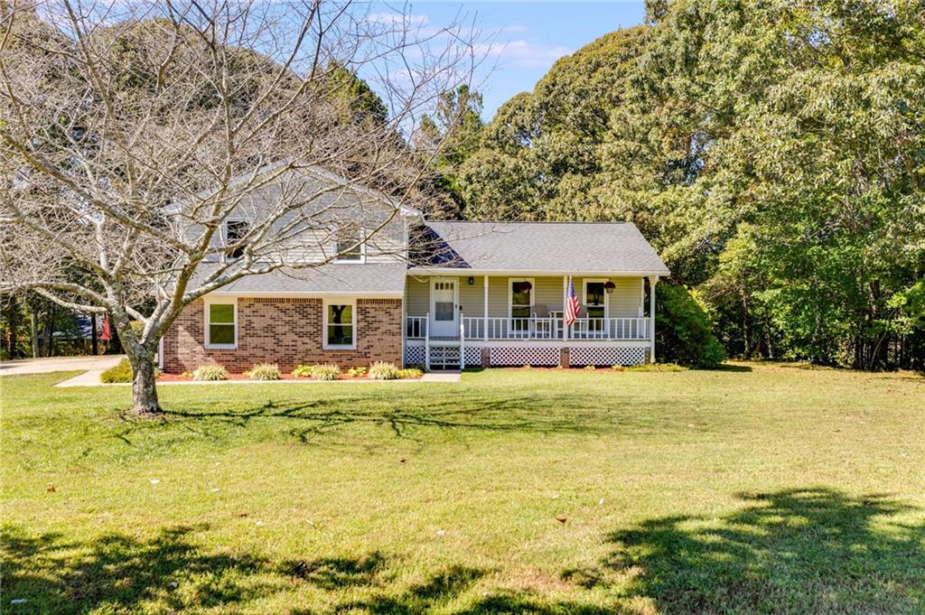 a front view of house with swimming pool and trees in the background