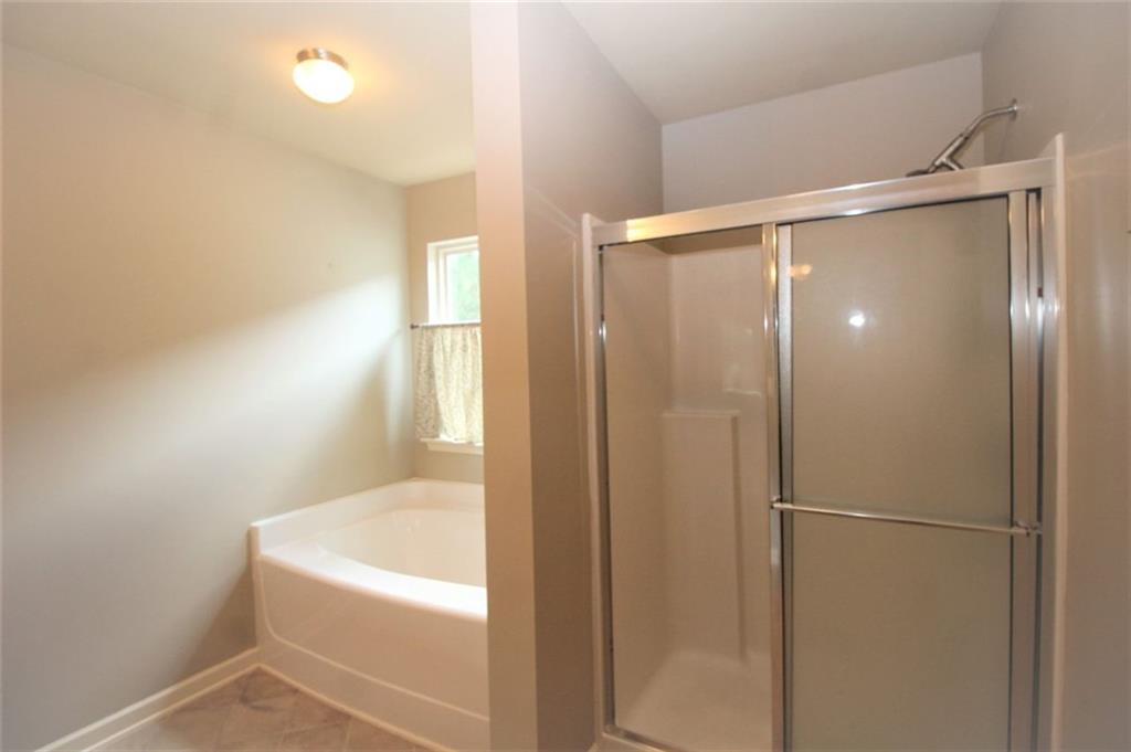 316 Alcovy Way Woodstock, GA 30188 - Photo 18 of 28 a bathroom with a bathtub and a shower