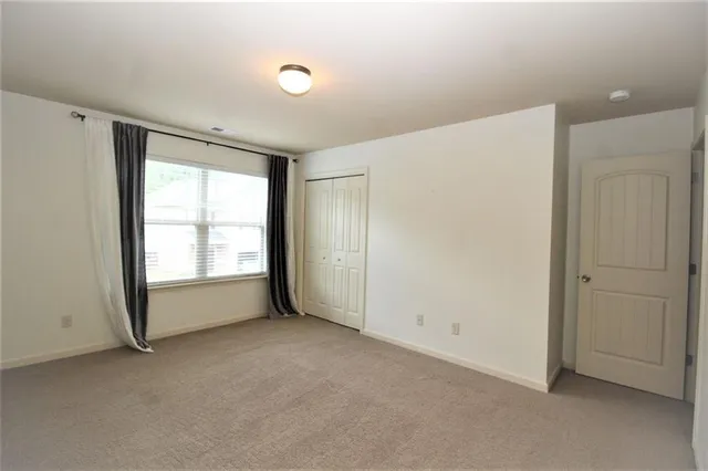 an empty room with windows and closet