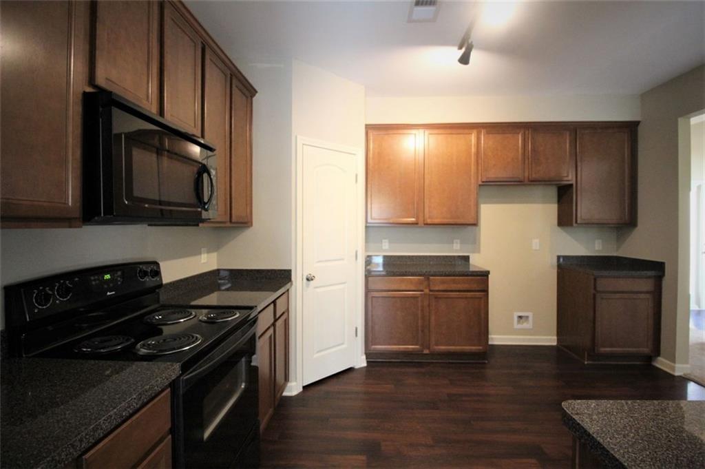 316 Alcovy Way Woodstock, GA 30188 - Photo 9 of 28 a kitchen with granite countertop wooden cabinets and a stove top oven