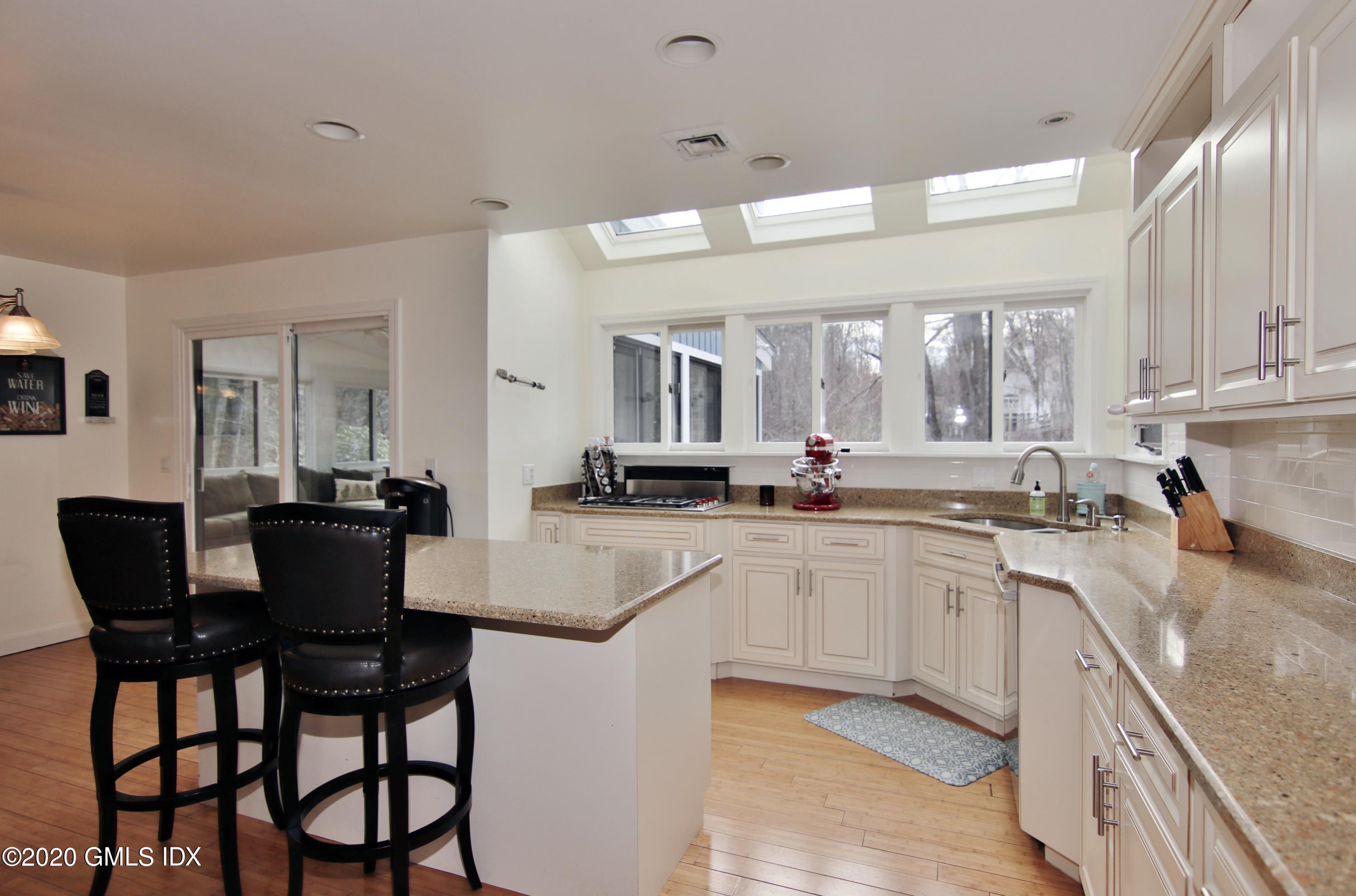 102 Gun Club Road Stamford, CT 06903 - Photo 12 of 41 a kitchen with stainless steel appliances granite countertop a table chairs sink and cabinets