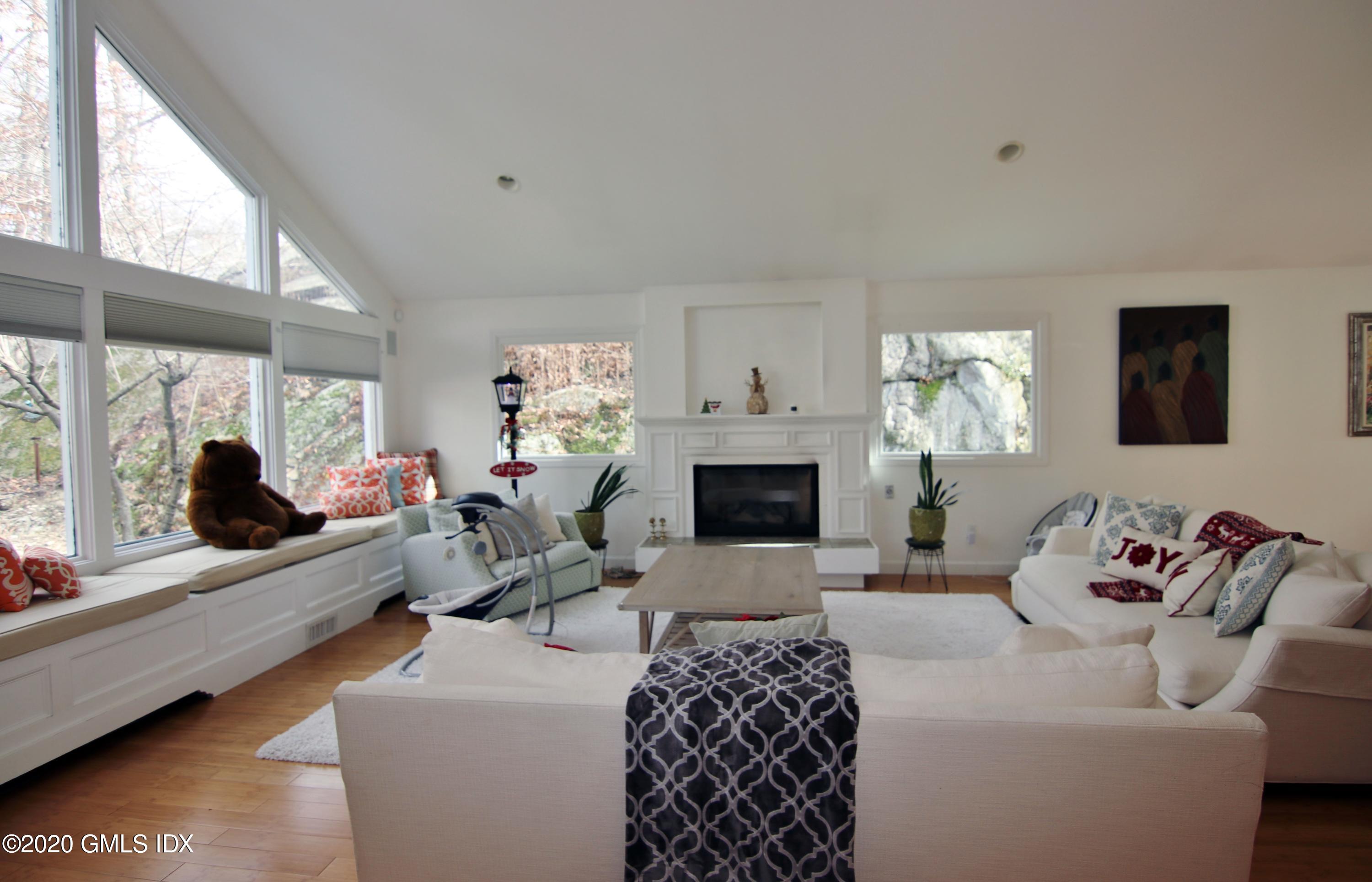 102 Gun Club Road Stamford, CT 06903 - Photo 4 of 41 a living room with furniture a fireplace and a large window