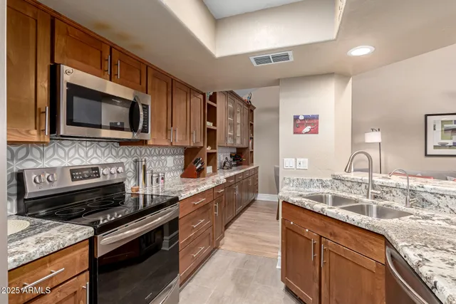 a kitchen with stainless steel appliances granite countertop a stove microwave and sink
