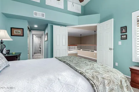 a bedroom with a bed and a large mirror on a dresser