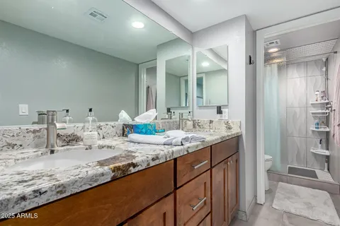 a bathroom with a granite countertop sink and a mirror
